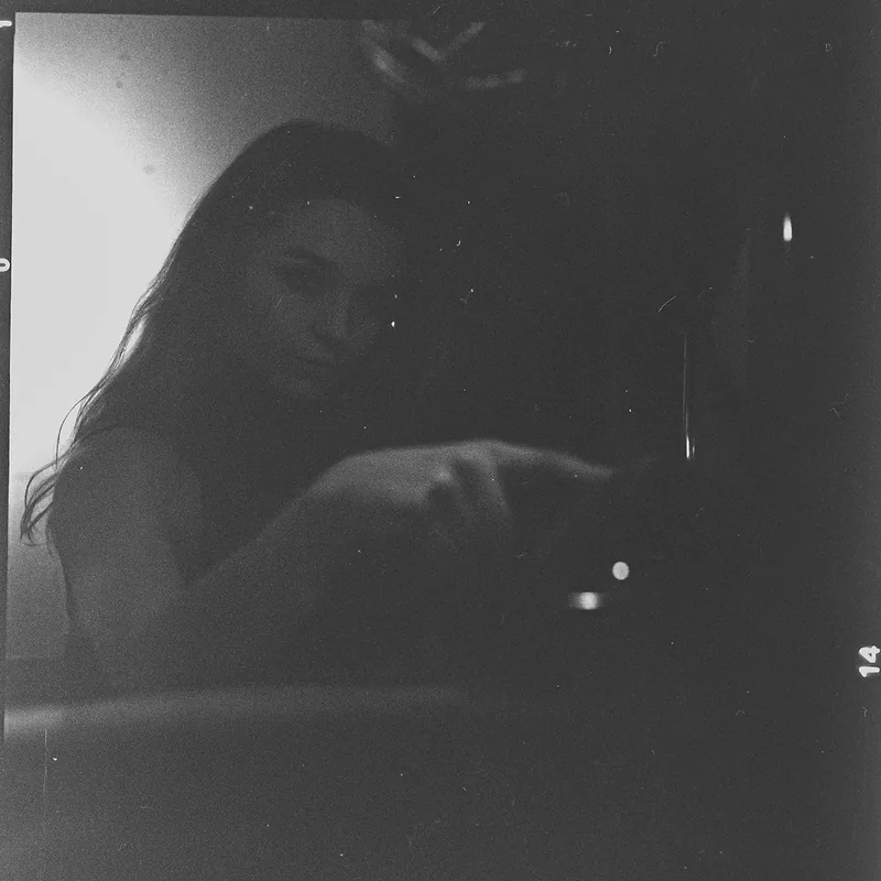 Analoges, körniges Portrait einer Frau im Halbschatten.