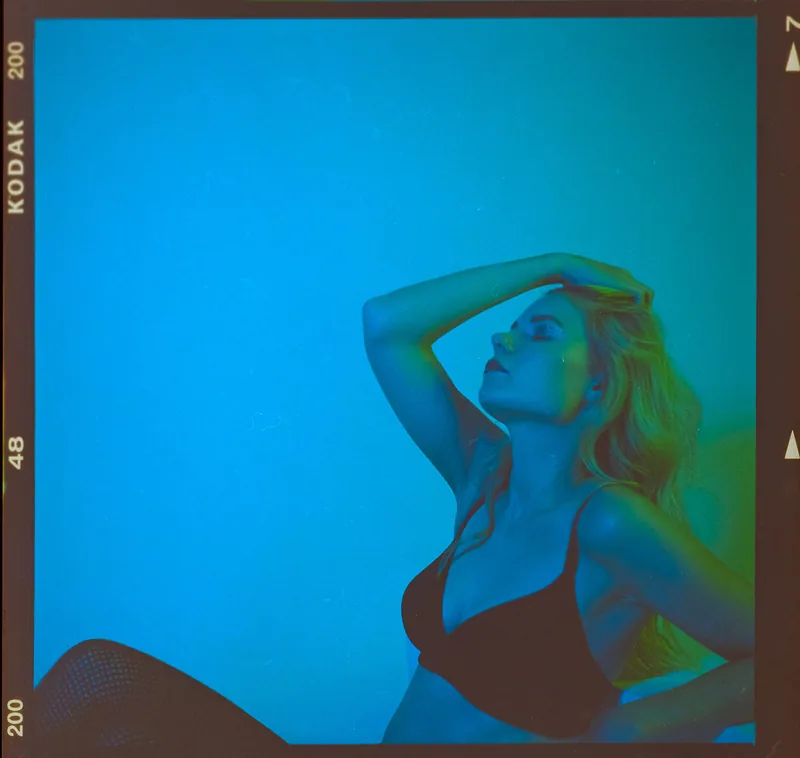 Analoges Portrait einer Frau in blauem und grünem Licht.