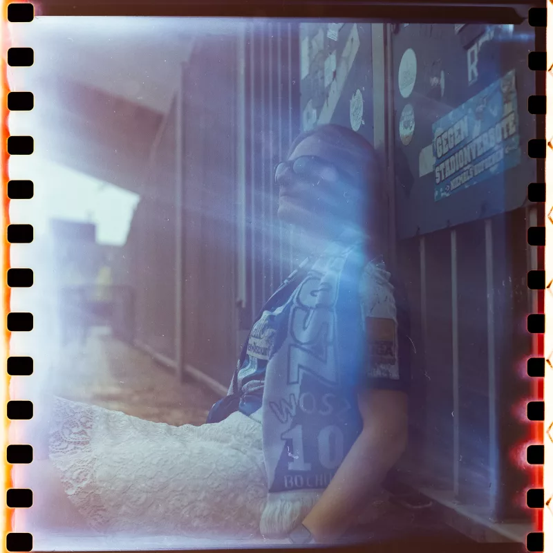 Analoges Portrait einer Person mit Sonnenbrille und blauem Schal