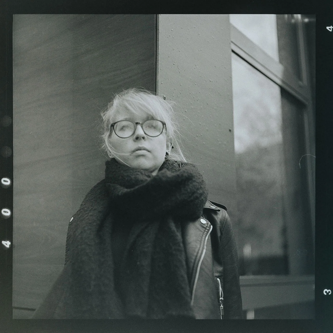 Analoges Schwarz-Weiß-Portrait einer Frau mit Brille und Schal
