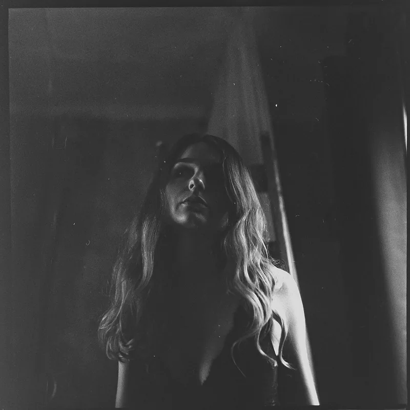 Analoges Schwarz-Weiß-Portrait einer Frau im dramatischen Licht.