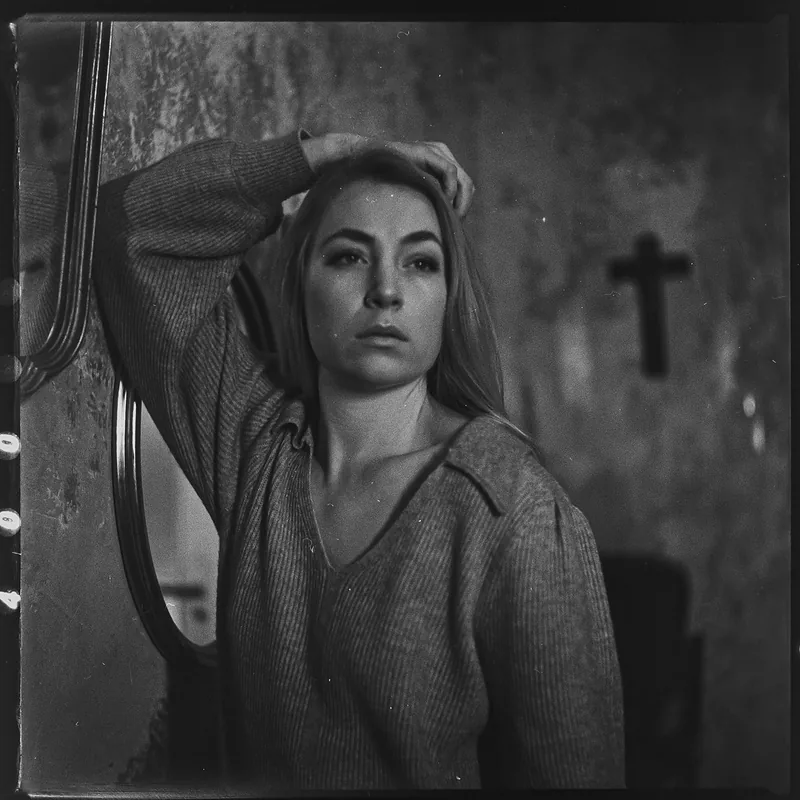 Analoges Schwarz-Weiß-Portrait einer Frau mit der Hand am Kopf.