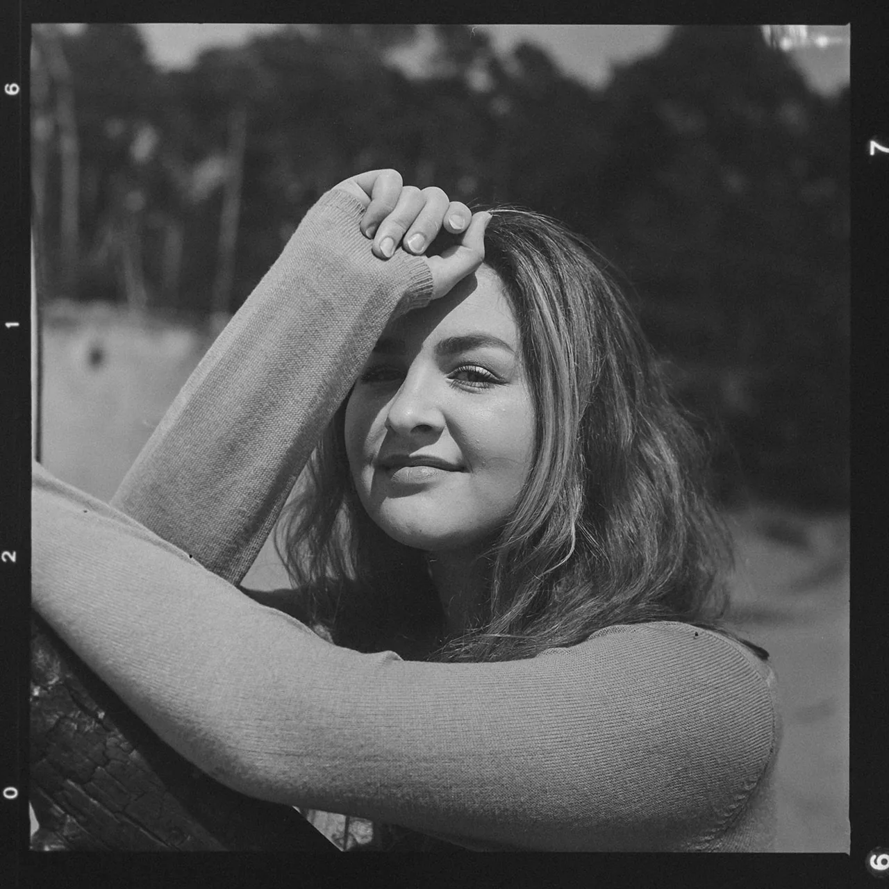 Analoges Schwarz-Weiß-Portrait einer Frau mit der Hand an der Stirn.
