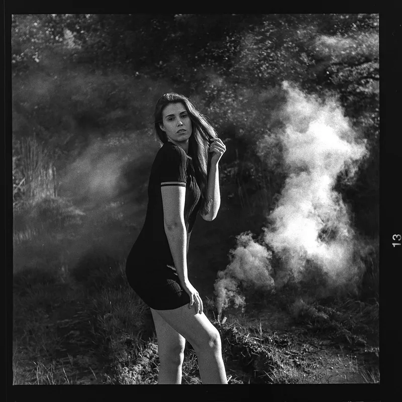 Analoges Schwarz-Weiß-Portrait einer Frau in einer nebligen Naturlandschaft.
