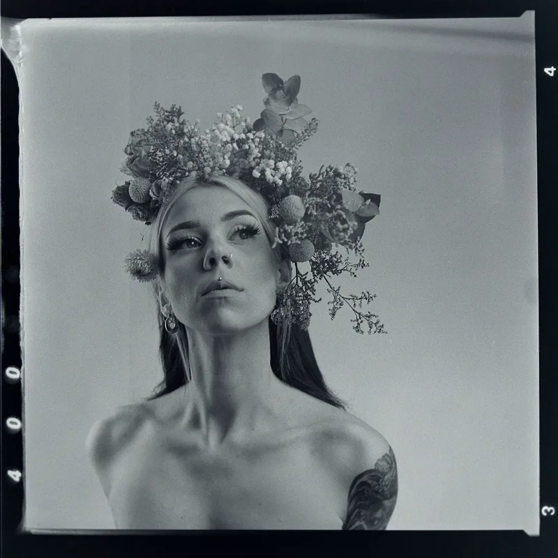 Analoges Schwarz-Weiß-Portrait einer Frau mit einem opulenten Blumenkranz.