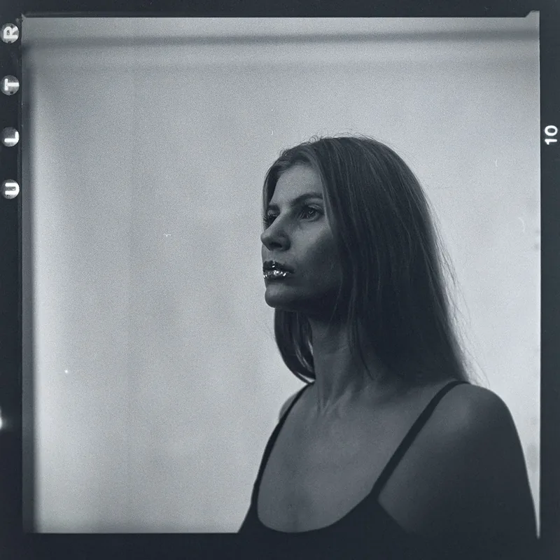 Analoges Schwarz-Weiß-Portrait einer Frau im Profil mit glitzernden Lippen.