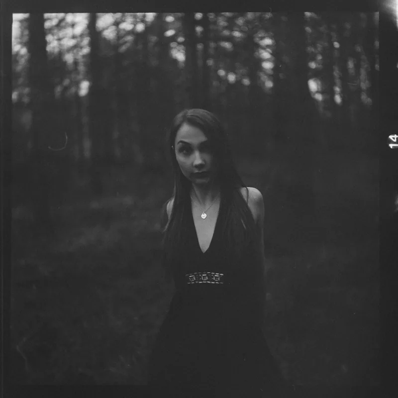 Analoges Schwarz-Weiß-Portrait einer Frau im Wald.