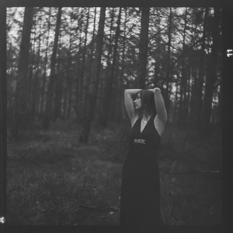 Analoges Schwarz-Weiß-Portrait einer Frau in einem Wald.