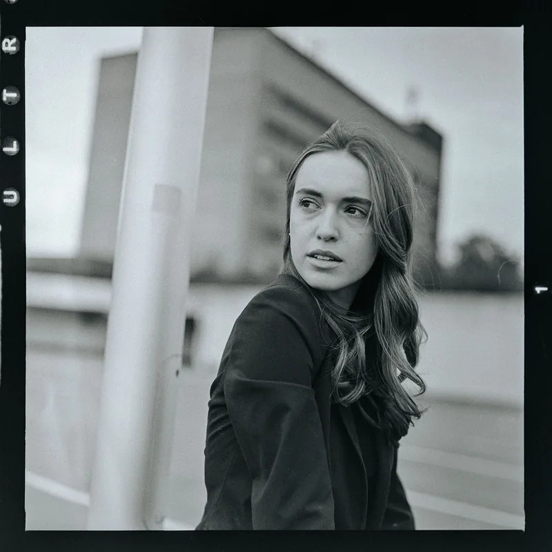 Analoges Schwarz-Weiß-Portrait einer jungen Frau mit Blick über die Schulter