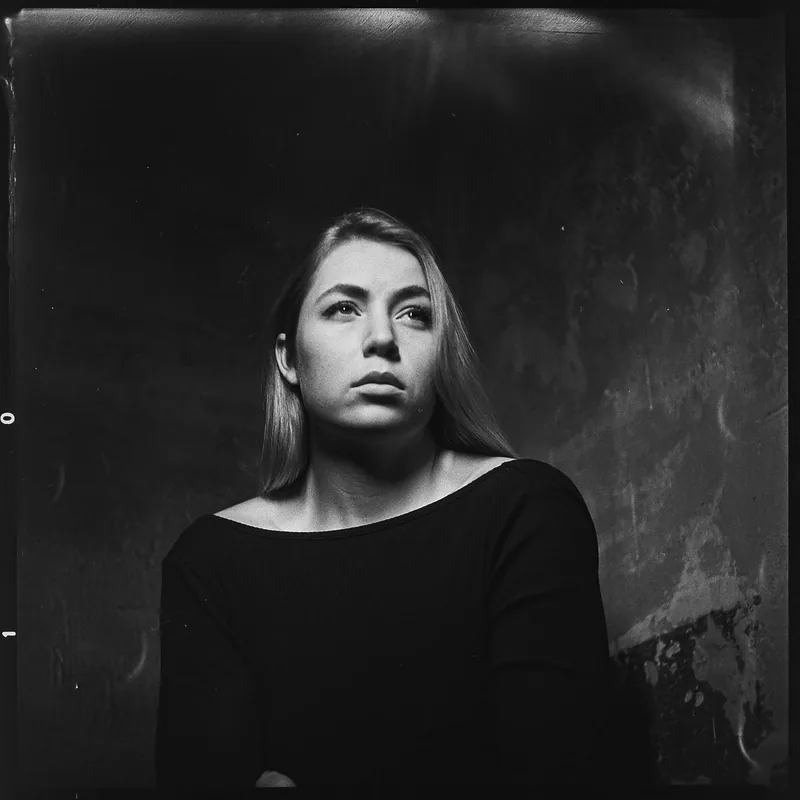 Analoges Schwarz-Weiß-Portrait einer jungen Frau mit nach oben gerichtetem Blick.