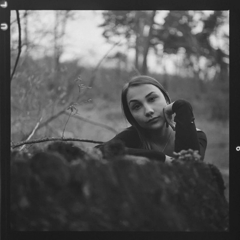Analoges Schwarz-Weiß-Portrait einer jungen Frau im Wald.