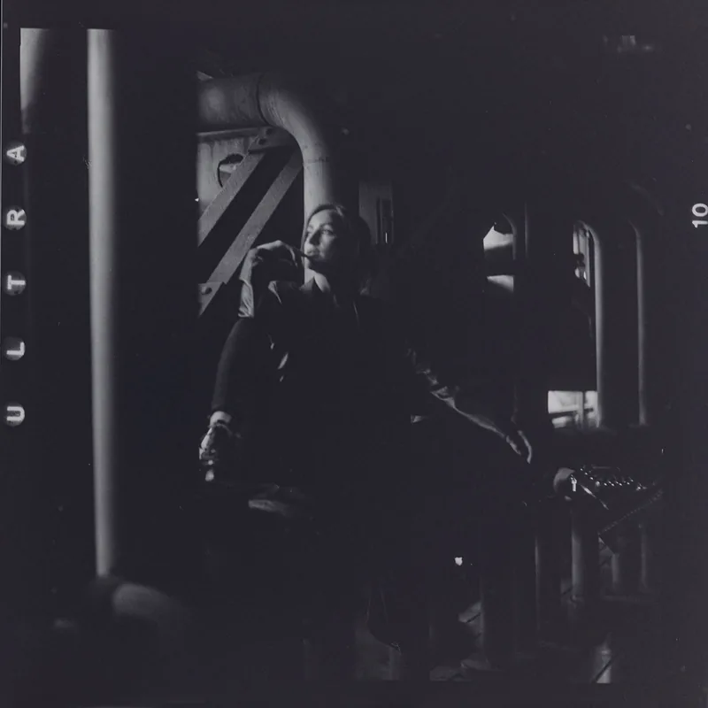 Analoges Schwarz-Weiß-Portrait einer Person in einer dunklen, industriellen Umgebung.