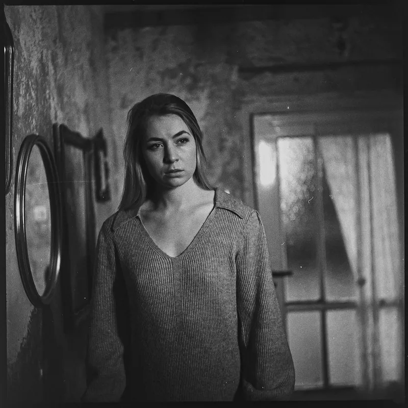 Analoges Schwarz-Weiß-Portrait einer Frau in einem rustikalen Innenraum