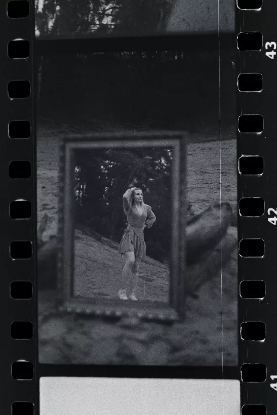 Analoges Schwarz-Weiß-Portrait einer Frau in einem gerahmten Bildauschnitt im Wald