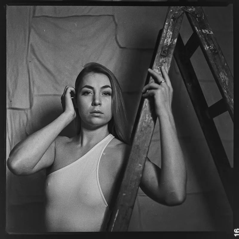 Analoges Studioportrait einer Frau in einem hellen One-Shoulder