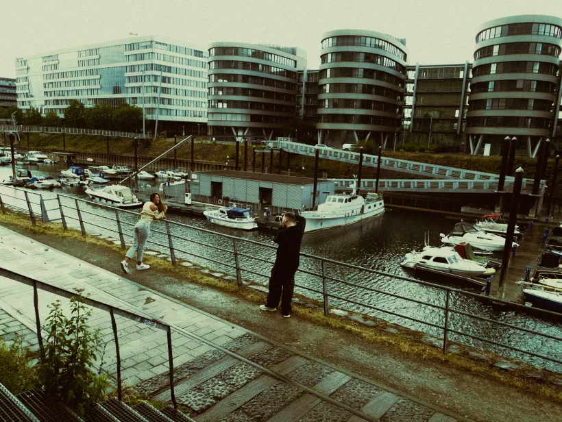 Architekturfotografie moderner Gebäude mit runden Fassaden an einem Kanal mit Booten
