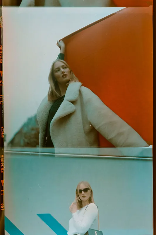Analoges Portrait einer blonden Frau in weißer Kleidung vor farbigen Hintergründen