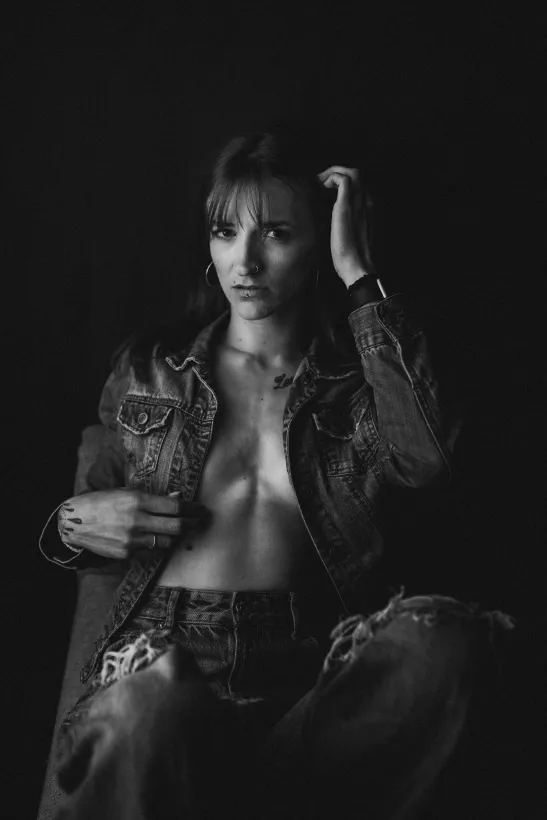 Boudoirfoto einer Frau in offener Jeansjacke in Schwarz-Weiß