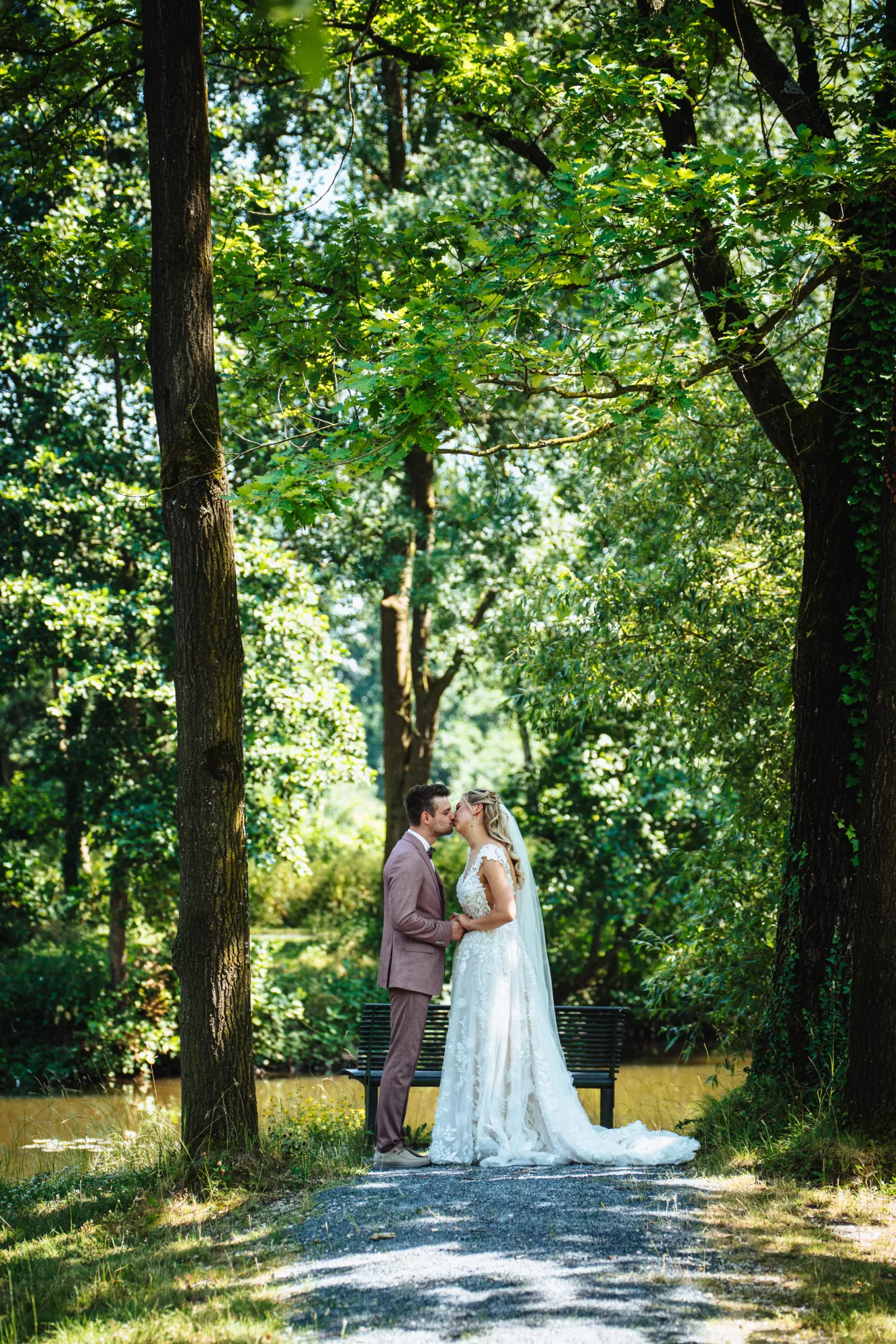 Romantisch küssendes Brautpaar im Sonnenlicht beim First Look vor der Hochzeit 