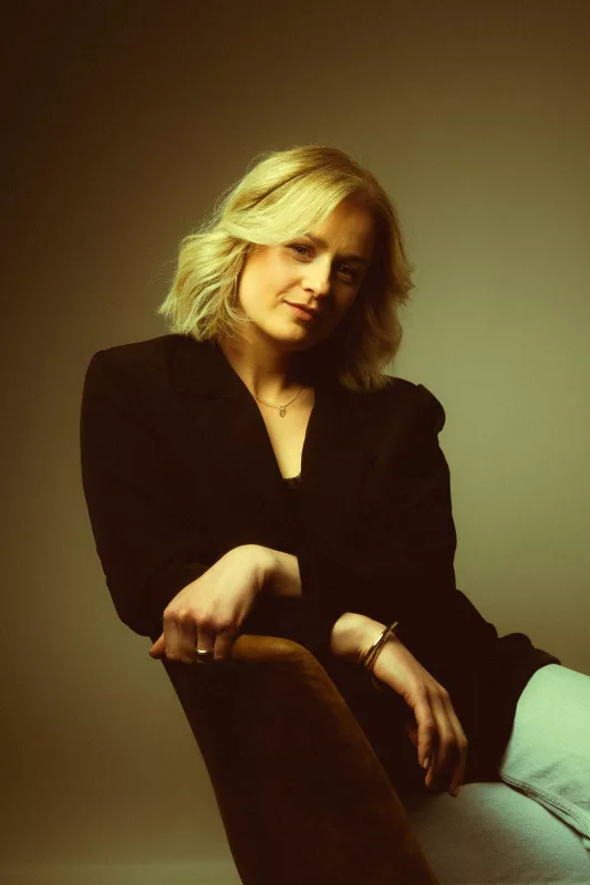 Businessportrait einer Frau mit blondem Haar in einem schwarzen Blazer