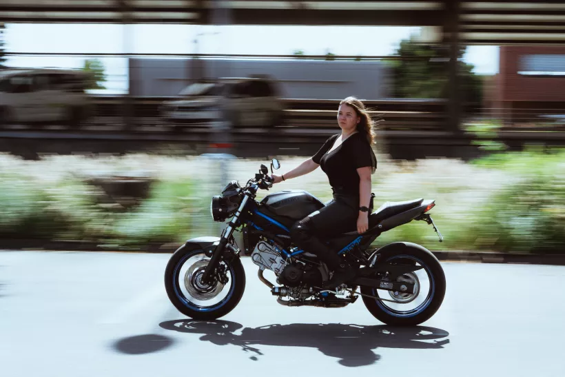 Dynamische Streetfotografie einer Frau auf einem schwarzen Motorrad mit Bewegungsunschärfe