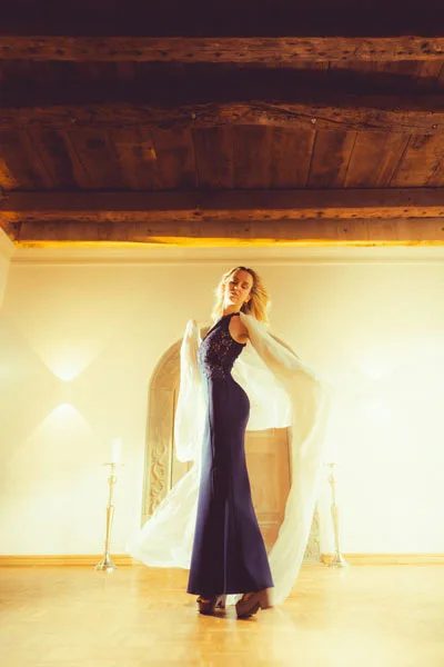 Elegantes Portrait einer Frau in einem dunkelblauen Abendkleid mit fließendem weißen Umhang