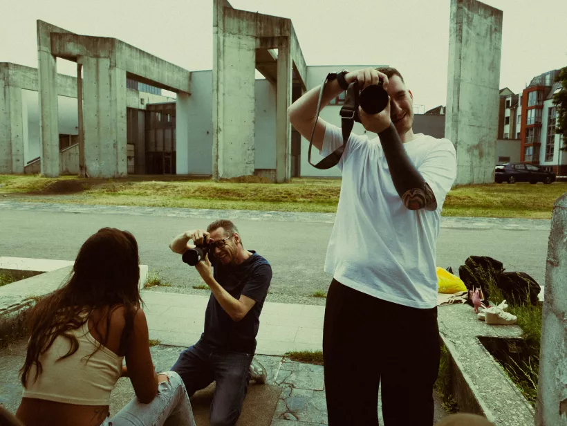 Fotografen bei der Arbeit mit Kameras vor moderner Betonarchitektur