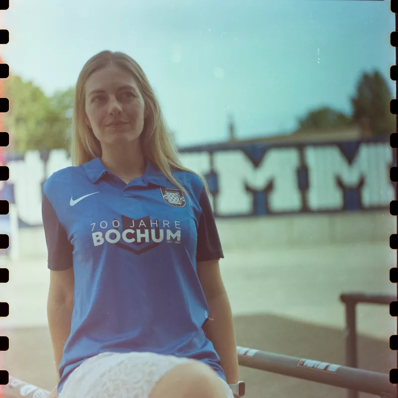 Analoges Portrait einer jungen Frau in einem blauen Fußballtrikot