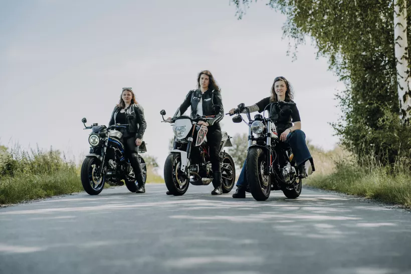 Outdoor-Portrait von drei Frauen auf Motorrädern an einer Landstraße
