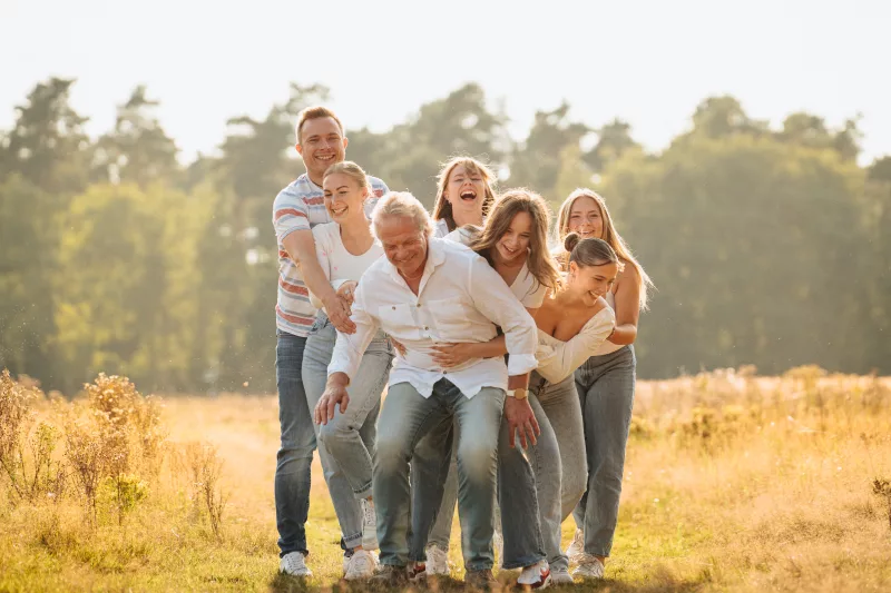 Fröhliche Gruppe bei einem Familienfoto auf einer sonnigen Wiese im warmen Licht