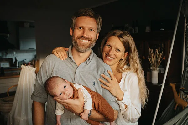 Herzliches Familienportrait eines lächelnden Paares mit Baby