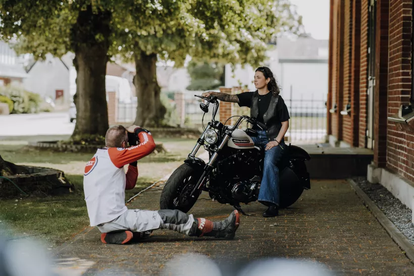 Lifestyle-Portrait einer Frau auf einem schwarzen Motorlag im Freien