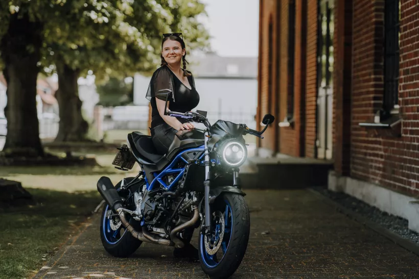 Lifestyle-Portrait einer lächelnden Frau auf einem schwarzen Motorrad