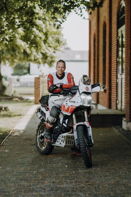 Portrait eines Mannes in Motorradbekleidung auf einem Adventure-Motorrad im Freien