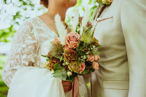 Nahaufnahme eines Hochzeitsstraum mit Rosen und Pampasgras.