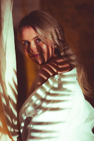 Portrait einer blonden Frau mit markanten Licht- und Schattenmustern im Gesicht