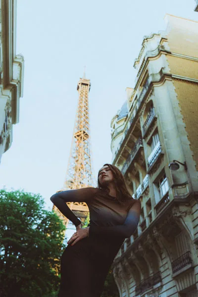 Portrait einer Frau vor dem Eiffelturm in Paris.