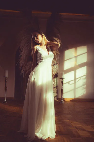 Portrait einer Frau in einem fließenden weißen Kleid im warmen Sonnenlicht