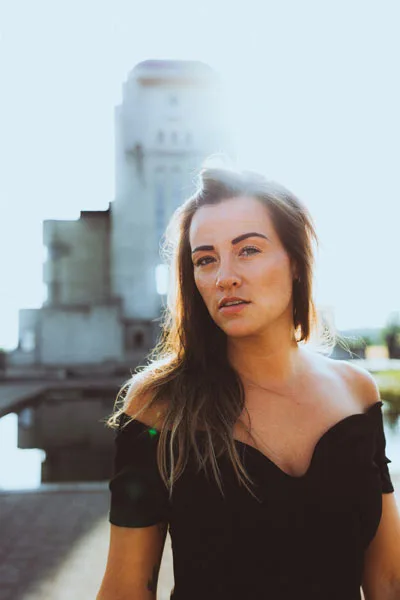 Portrait einer Frau vor hellem, unscharfem Hintergrund.
