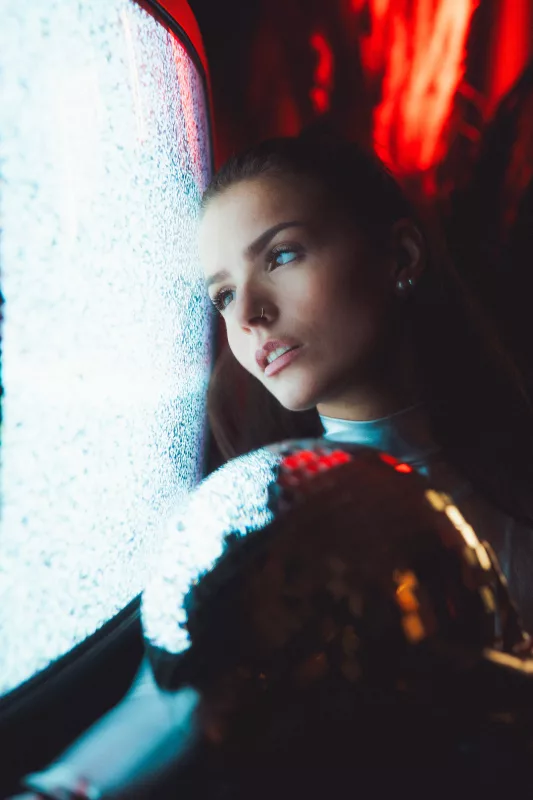 Portrait einer Frau in kontrastreichem blauem und rotem Licht.