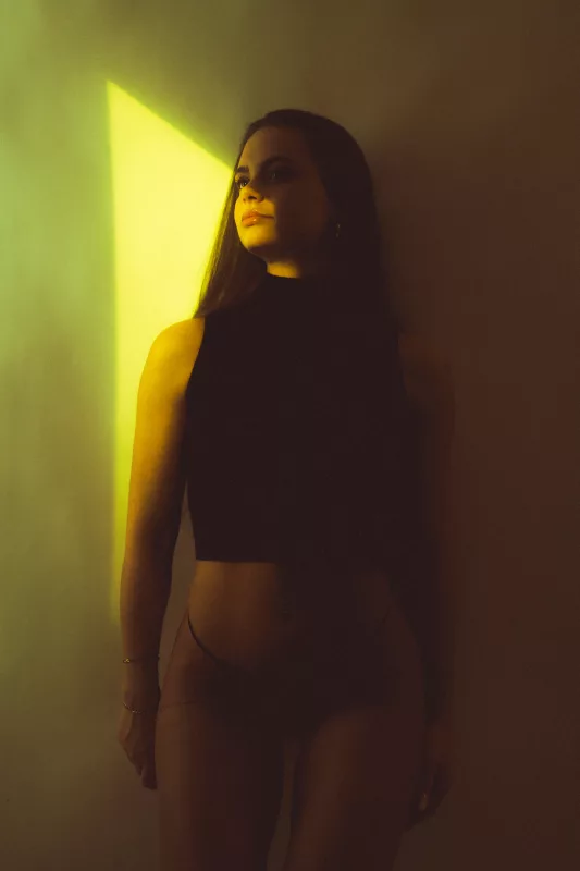Portrait einer Frau mit langem Haar im seitlichen gelben Lichtschein.