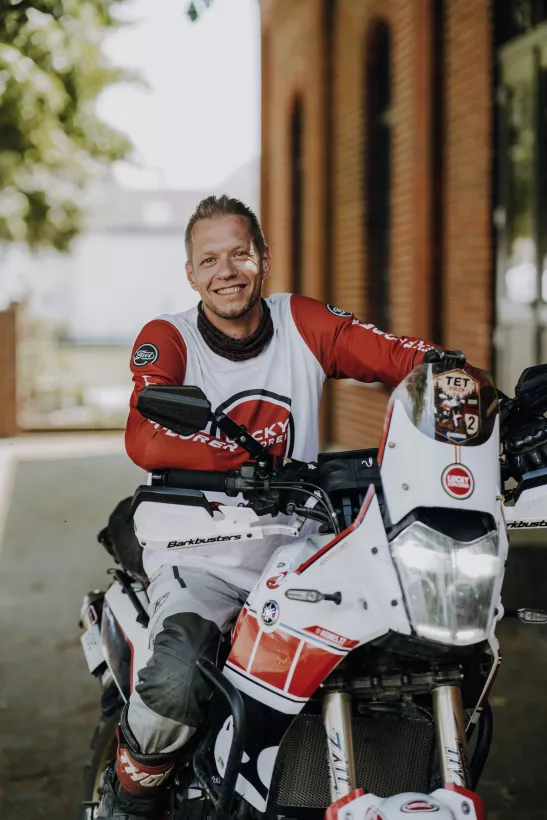 Portrait eines lächelnden Mannes auf einem Adventure-Motorrad