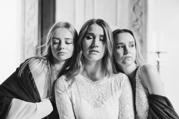 Schwarz-weiß Portrait von drei Frauen mit geschlossenen Augen.
