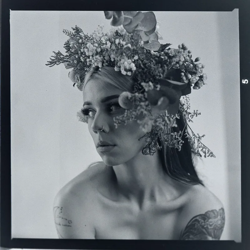 Schwarz-weiß-Portrait einer Frau mit einem detailreichen Blumenkranz