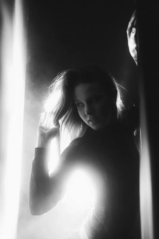 Schwarz-weiß Portrait einer Frau in kontrastreichem Gegenlicht.