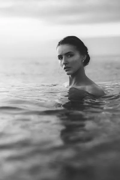 Schwarz-weiß Portrait einer Frau im Meerwasser.