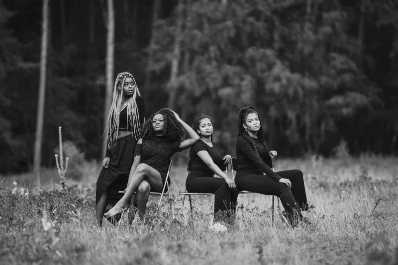 Schwarz-weißes Portrait von vier Frauen in einer Waldlandschaft