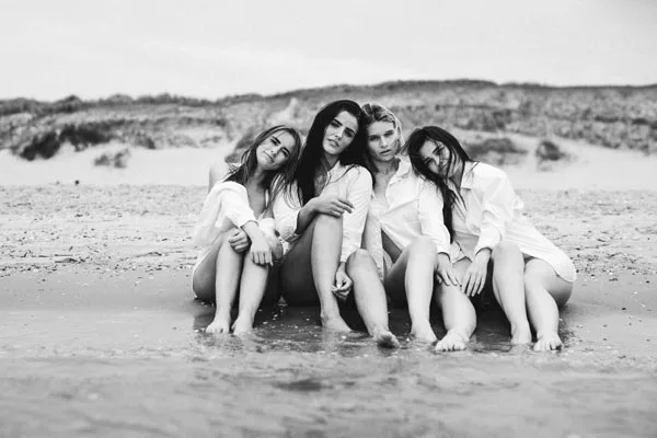 Schwarz-Weiß-Portrait von vier jungen Frauen am Strand