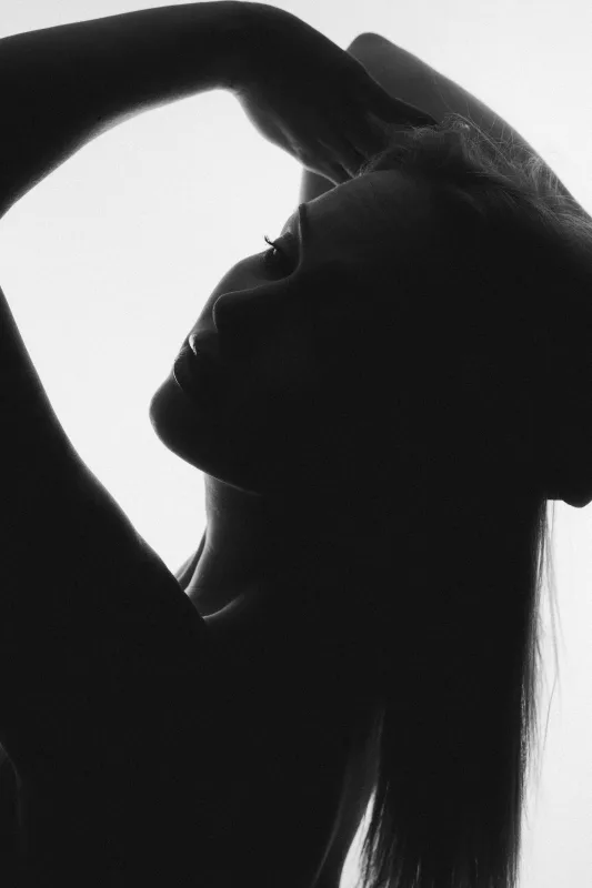 Schwarz-weiß Silhouette eines Frauenprofils mit erhobenem Arm.