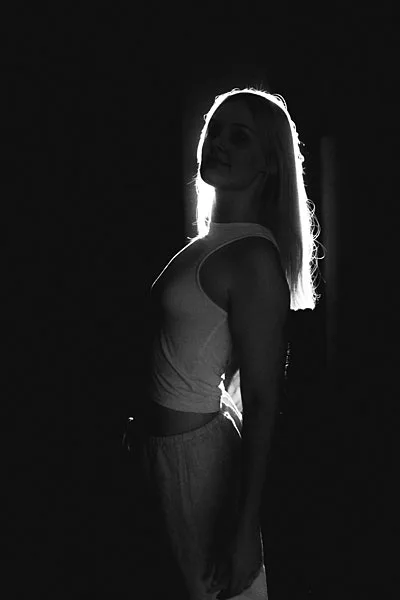 Schwarz-weißes Portrait einer Frau mit markanter Lichtkante am Profil.